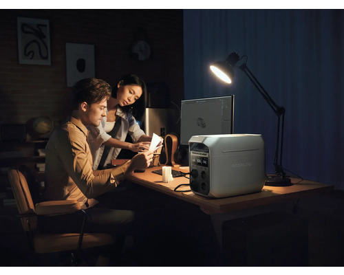 Pár pracuje pri stole s napájacou stanicou EcoFlow, počítačom a stolnou lampou.