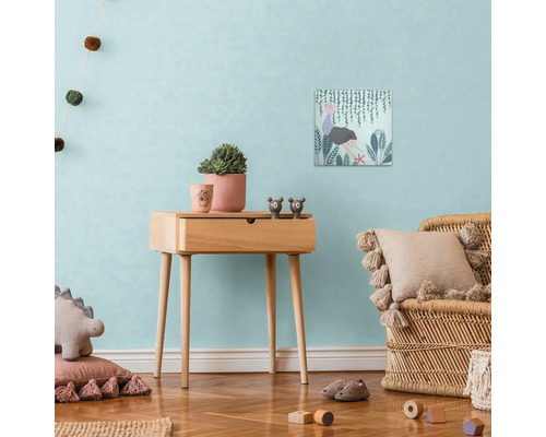 Dekoratívna scéna detskej izby s dreveným príručným stolíkom, plátennou potlačou, črepníkovými rastlinami a ratanovým kreslom