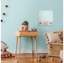 Výzdoba detskej izby s plátenným obrazom, odkladacím stolíkom a ratanovým kreslom.