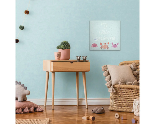 Výzdoba detskej izby s plátenným obrazom, odkladacím stolíkom a ratanovým kreslom.