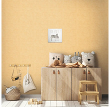 Detská izba s dreveným nábytkom, ozdobnými vankúšmi, stoličkou a obrázkom zebry s nápisom Be Cute.