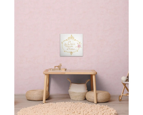 Scéna detskej izby so stolom, kobercom, pufmi a nástennou maľbou s textom „Kde bolo, tam bolo“