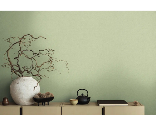 Dekoratívna scéna s vázou, vetvami, čajovou kanvicou a ďalšími dekoratívnymi prvkami na komode pred stenou