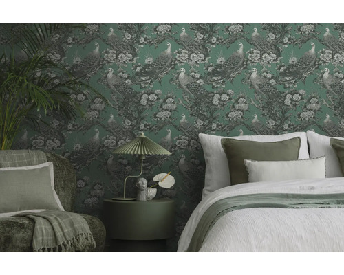 Dekoratívna spálňa s vzorovanou tapetou, posteľou, kreslom a príručným stolíkom