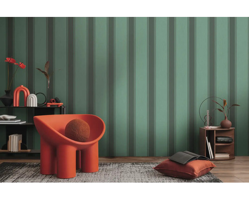 Zariadená obývacia izba s pruhovanou tapetou, kreslom, kobercom a odkladacím stolíkom.