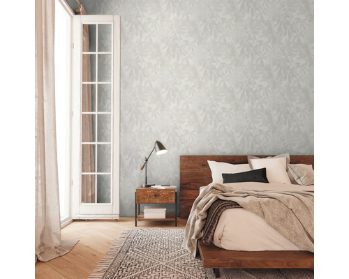 Spálňa s manželskou posteľou, nočným stolíkom, lampou a vzorovanou tapetou