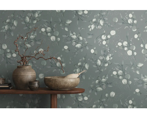 Dekoratívna stena s eukalyptovým vzorom a bytovými doplnkami na stole.