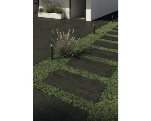 Kamenné terasové dosky tvoria cestu záhradou, osvetlenú záhradnými lampami.