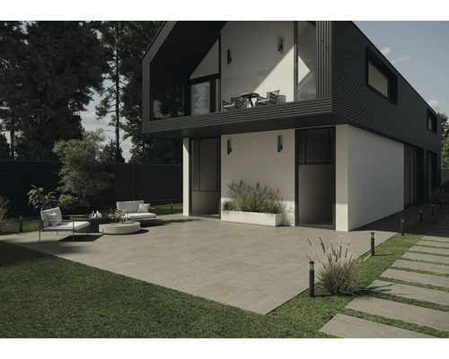 Vonkajší pohľad na moderný dom s terasou, záhradným nábytkom a dlažobnými kockami