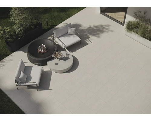 Záhradná scéna s terasovými dlaždicami, ohniskom a záhradným nábytkom.