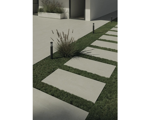 Kamenné chodníkové dosky v záhrade s trávnikom a dekoratívnymi lampami