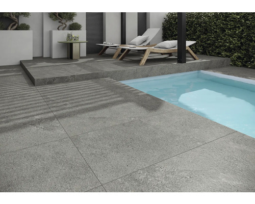 Exteriér so sivými dlaždicami, bazénom a ležadlami