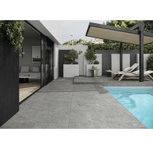 Vonkajší priestor so sivými dlaždicami, bazénom, ležadlami a pergolou