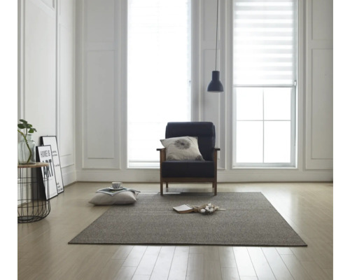 Obývacia izba s kobercom, kreslom a roletami pre denné svetlo na oknách