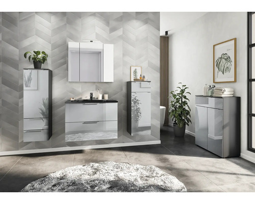 Moderná kúpeľňa s umývadlovou skrinkou, zrkadlovou skrinkou a vysokou skrinkou pred vzorovanou stenou.