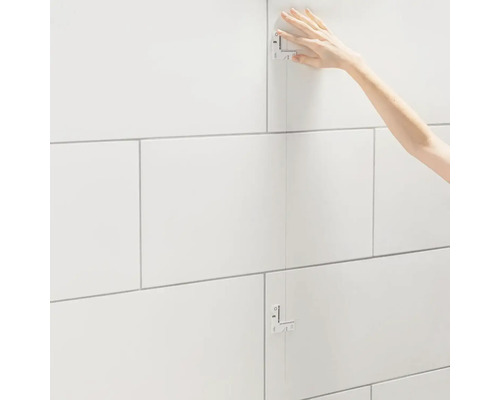 Obkladač kladie obklady stien pomocou šablóny na obklady