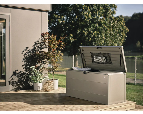 Otvorený úložný box na drevenej terase s rastlinami v pozadí