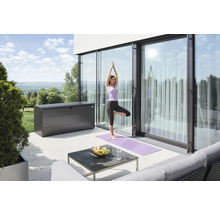 Terasa s úložným boxom, stolom a ženou cvičiacou jogu