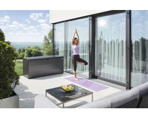 Terasa s úložným boxom, stolom a ženou cvičiacou jogu