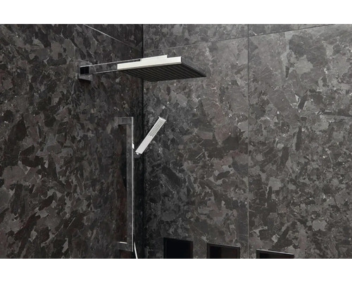 Moderná sprcha s hornou a ručnou sprchou pred tmavou kamennou stenou.