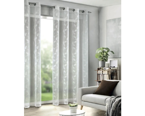 Priehľadný záves s očkami a motívom listov pred oknom