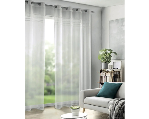 Priehľadné závesy s očkami pred oknom v obývacej izbe