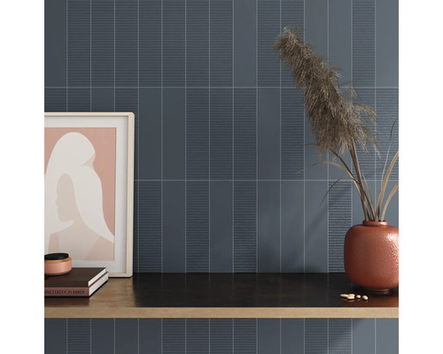 Nástenná dekorácia s podlhovastými dlaždicami a dekoratívnymi prvkami na poličke