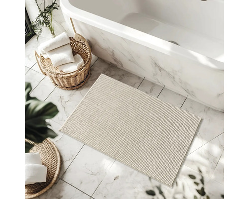 Kúpeľňa so scénou s vaňou, kúpeľňovým kobercom a košmi s uterákmi