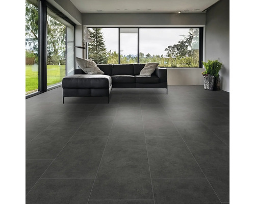Moderná obývacia izba s veľkoformátovými sivými podlahovými dlaždicami a čiernou koženou sedačkou
