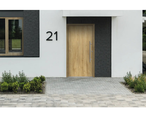 Fasáda domu s vchodovými dverami, číslo domu 21 a dláždeným chodníkom
