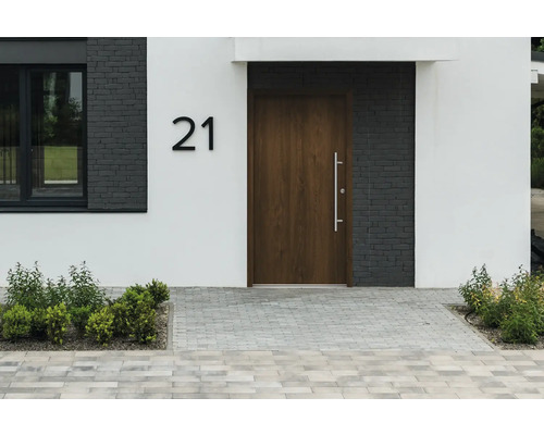 Fasáda domu s vchodovými dverami, číslom domu 21 a dláždenou cestou
