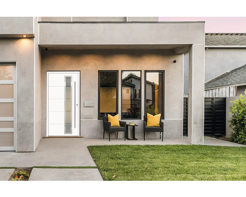 Fasáda domu s modernými vchodovými dverami, oknami a vonkajším posedením.