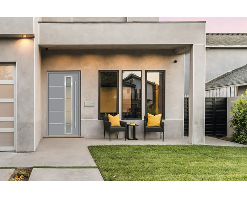 Moderná fasáda domu s vchodovými dverami, oknami a vonkajším posedením.