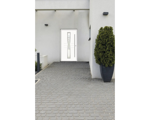 Moderné vchodové dvere so sklenenou vložkou a dlhou kľučkou na obytnom dome