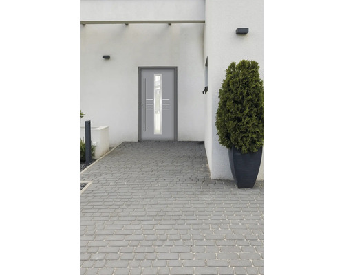 Moderné vchodové dvere so sklenou vložkou a nerezovou rukoväťou v svetlej budove.