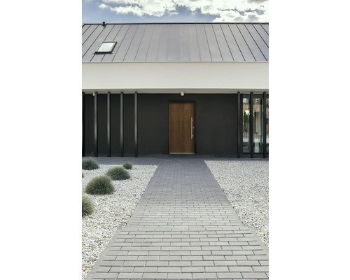 Predný pohľad na moderný dom s dláždenou cestou, štrkom a drevenými dverami.