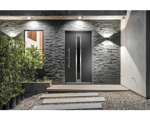 Vstupný priestor domu s modernými vchodovými dverami, kamennou stenou a dekoratívnymi prvkami