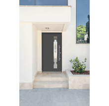 Moderné vchodové dvere so sklenenou vložkou a nerezovou kľučkou vo svetlej budove.