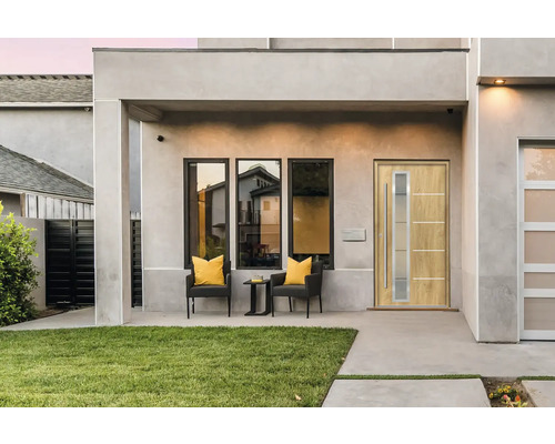 Moderná fasáda domu s vchodovými dverami, oknami a posedením na terase