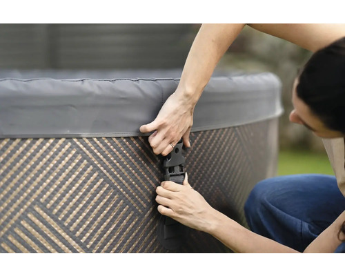 Osoba upevňuje kryt vírivky pomocou praciek