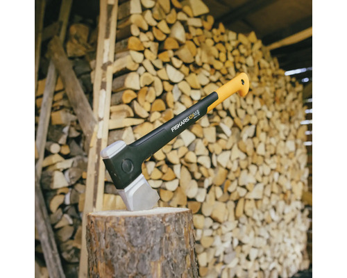 Sekera na pni pred hromadou dreva