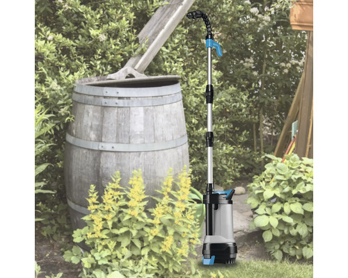 Čerpadlo do dažďovej nádrže používané v záhrade vedľa suda na dažďovú vodu
