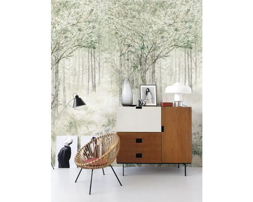Pohľad na izbu s tapetou s motívom lesa, komodou a prúteným kreslom