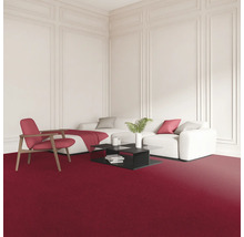 Obývacia izba s červeným kobercom, bielou pohovkou, kreslom a čiernym konferenčným stolíkom