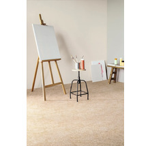 Scéna s maliarskym stojanom, plátnom, stoličkou, štetcami, farbami a malým stolom vo svetlej miestnosti.