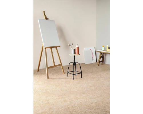 Scéna s maliarskym stojanom, plátnom, stoličkou, štetcami, farbami a malým stolom vo svetlej miestnosti.