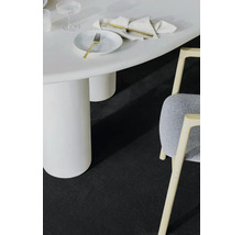 Detailný záber miestnosti s bielym stolom, stoličkou a tmavým kobercom