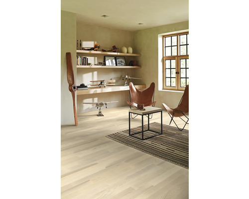 Svetlá miestnosť s drevenou podlahou, policami, dekoráciou a dvoma koženými kreslami