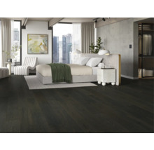 Spálňa s tmavou drevenou podlahou, posteľou a bielym kreslom