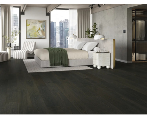 Spálňa s tmavou drevenou podlahou, posteľou a bielym kreslom